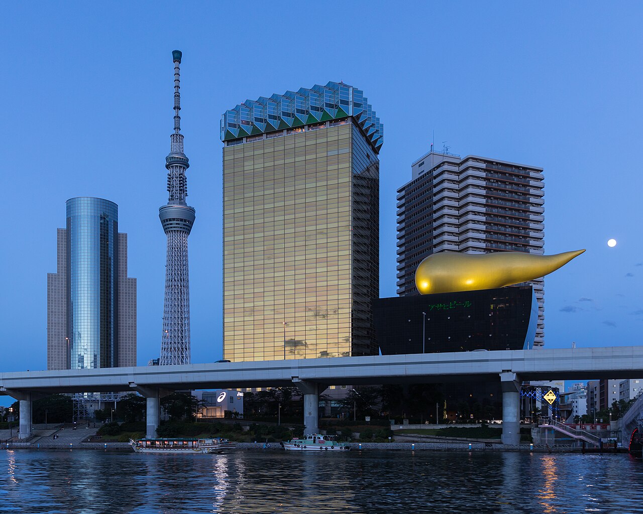 Asahi Breweries headquarters building with the Asahi Flame and Skytree at blue hour with full moon, Sumida ku, Tokyo, Japan