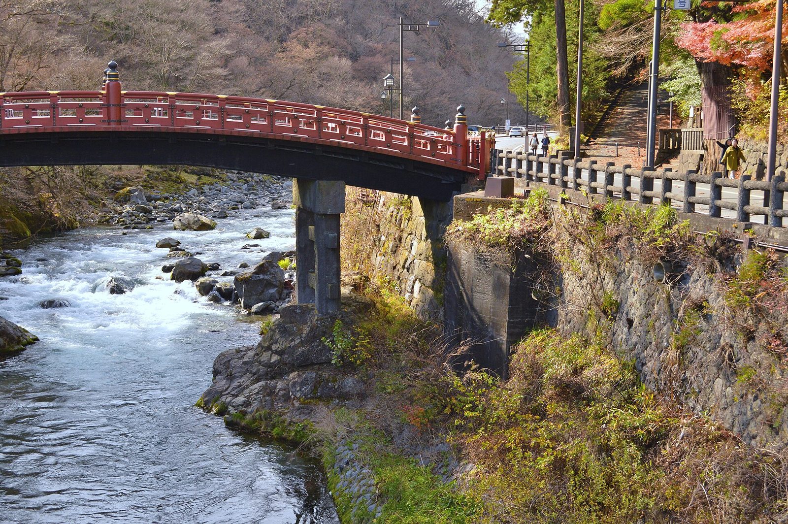สะพานชินเคียวสีแดงข้ามแม่น้ำไดยะที่ไหลแรงผ่านโขดหิน